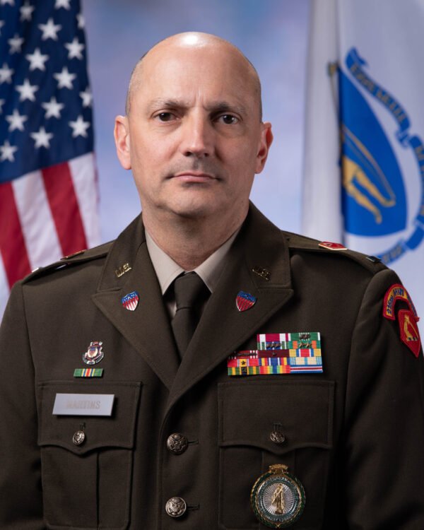 CW4 Stephen Martins in AGSU Uniform with American Flag and Massachusetts Flag in the background.