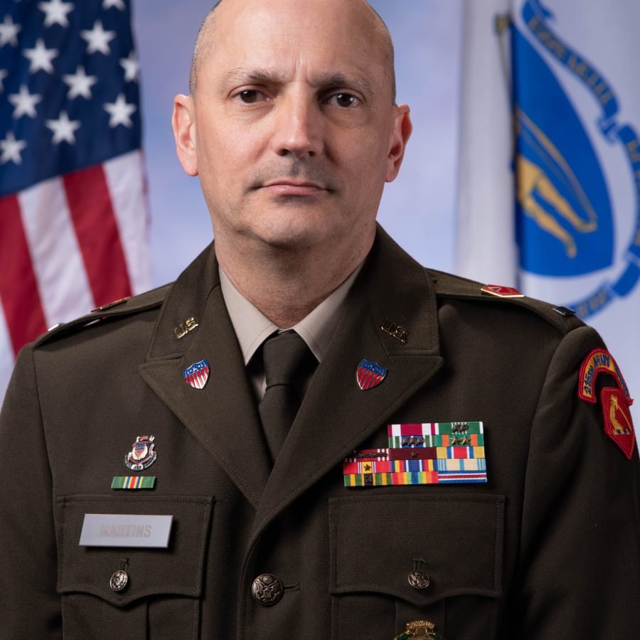 CW4 Stephen Martins in AGSU Uniform with American Flag and Massachusetts Flag in the background.